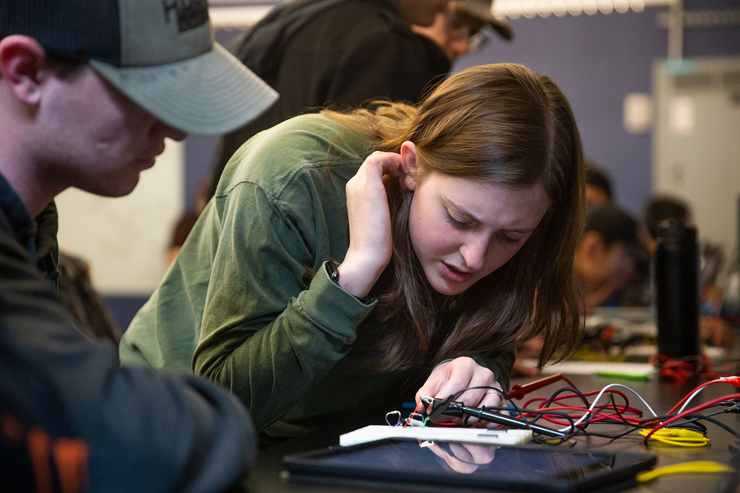 Female student works with circuit board in a Min H. Kao Engineering Building Lab
