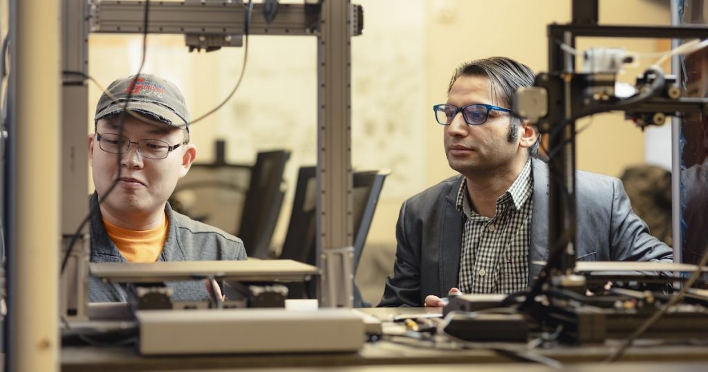 Himanshu Thapliyal and student working on a 3D printer