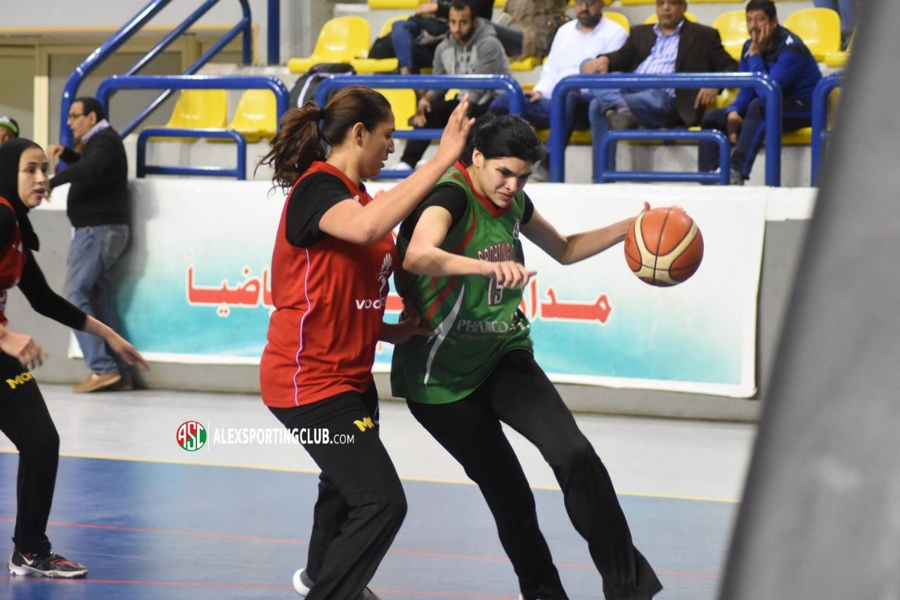 Ran Elgedawy playing basketball, dribbling the ball while a player on the other team tries to block her